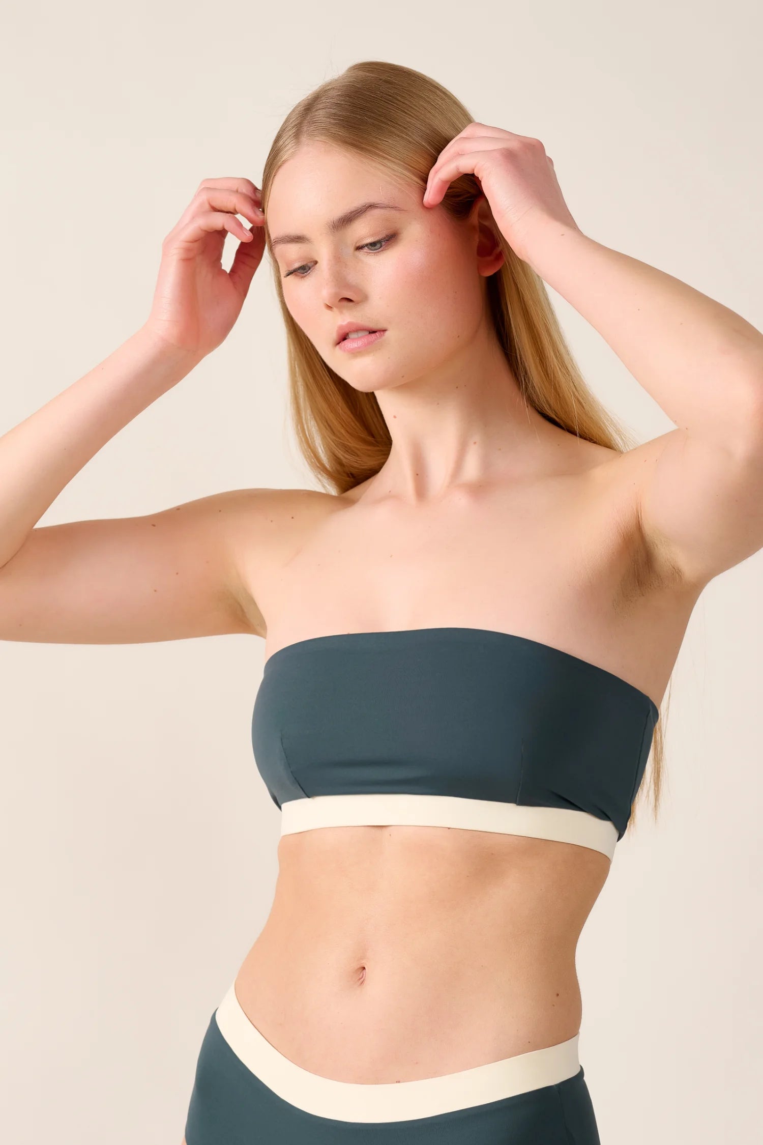 Frau trägt MYMARINI Bandeau-Bikinitop mit breitem, kontrastierendem Saum.#color_black-grey-white