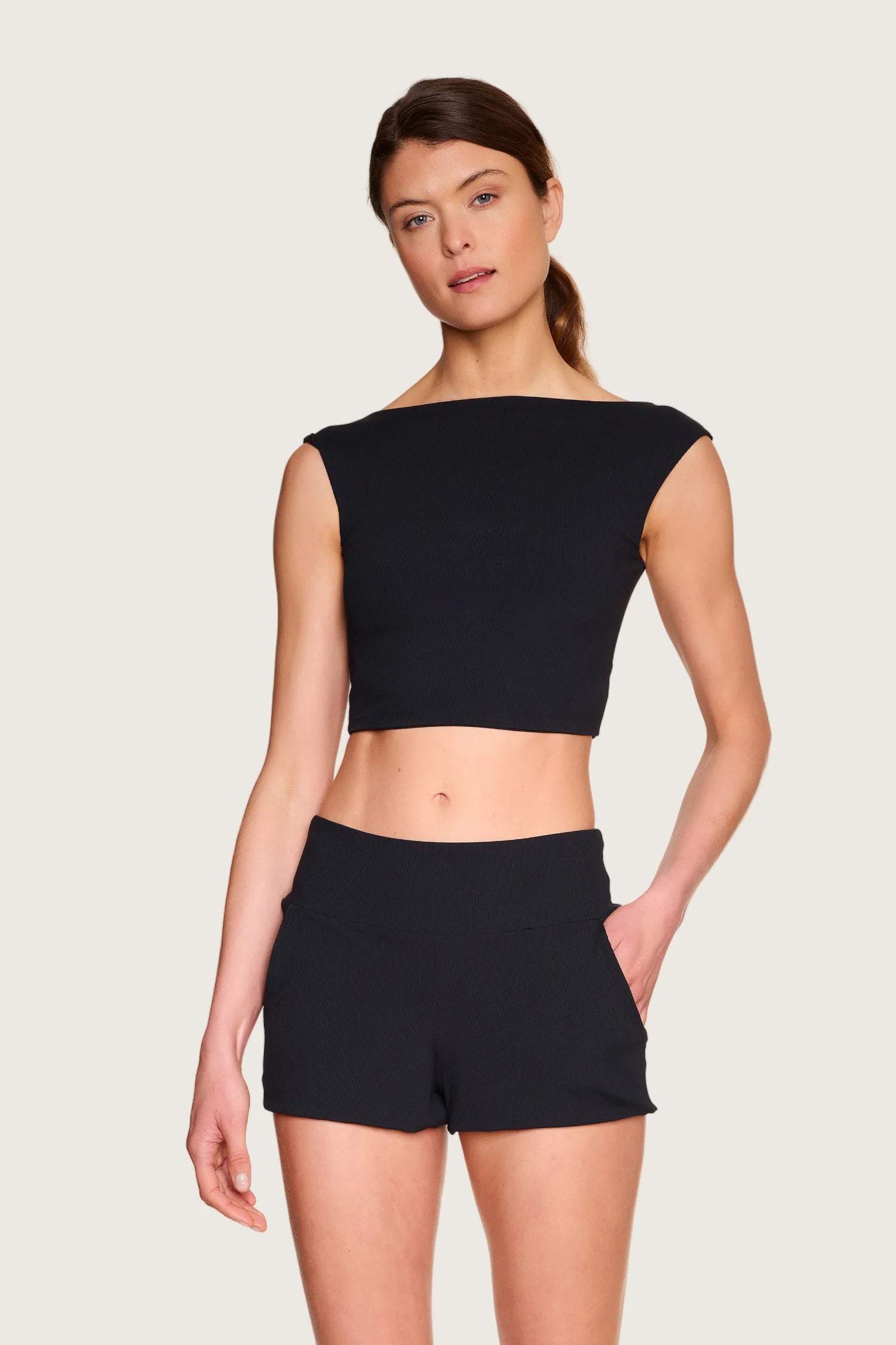 Frau trägt schwarzes MYMARINI-Top mit breiten Trägern und passende Shorts.#color_black