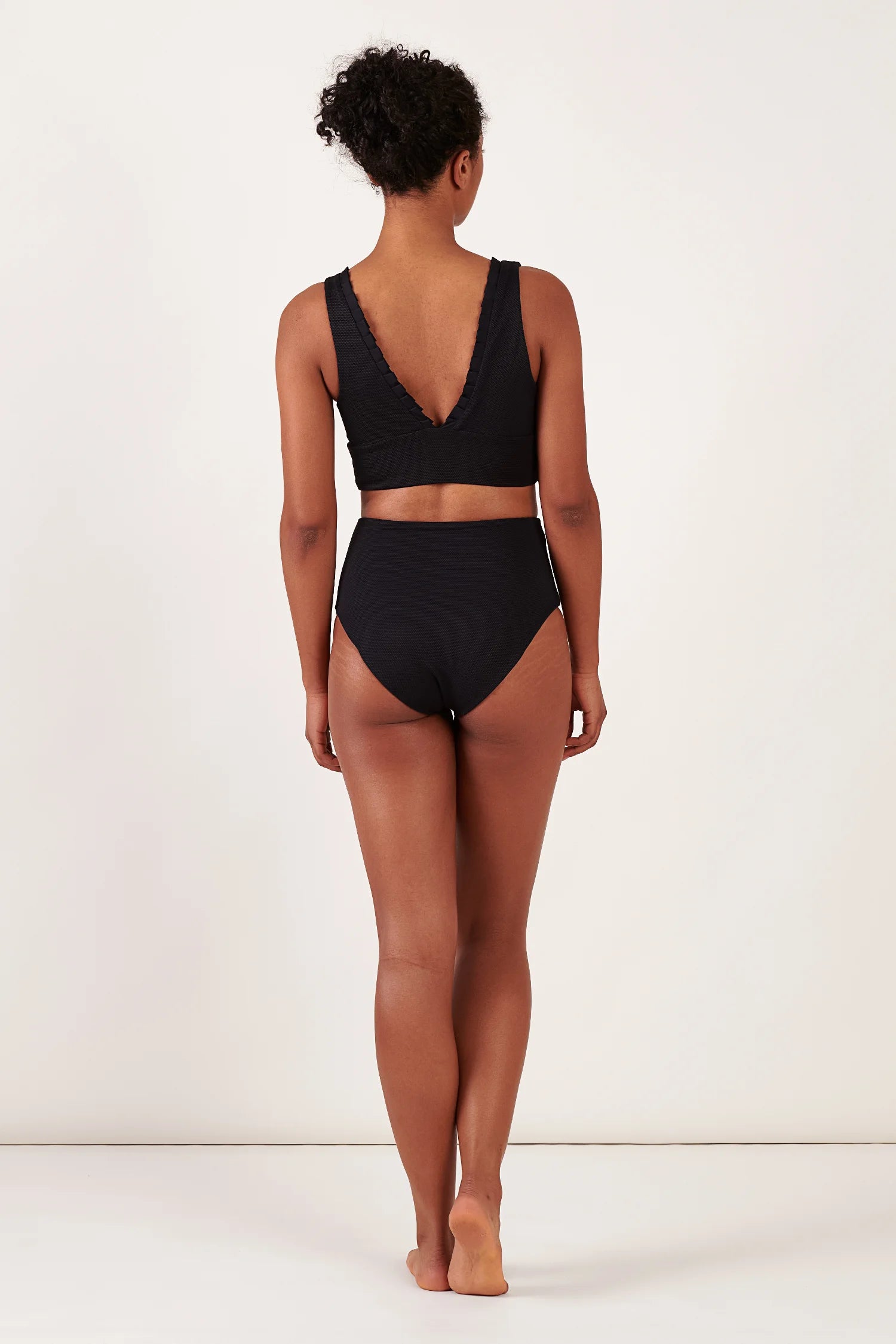 Schwarzes Bikinitop mit V-Ausschnitt und breiten Trägern sowie passende hohe Bikinihose von MYMARINI, von hinten sichtbar.#color_black