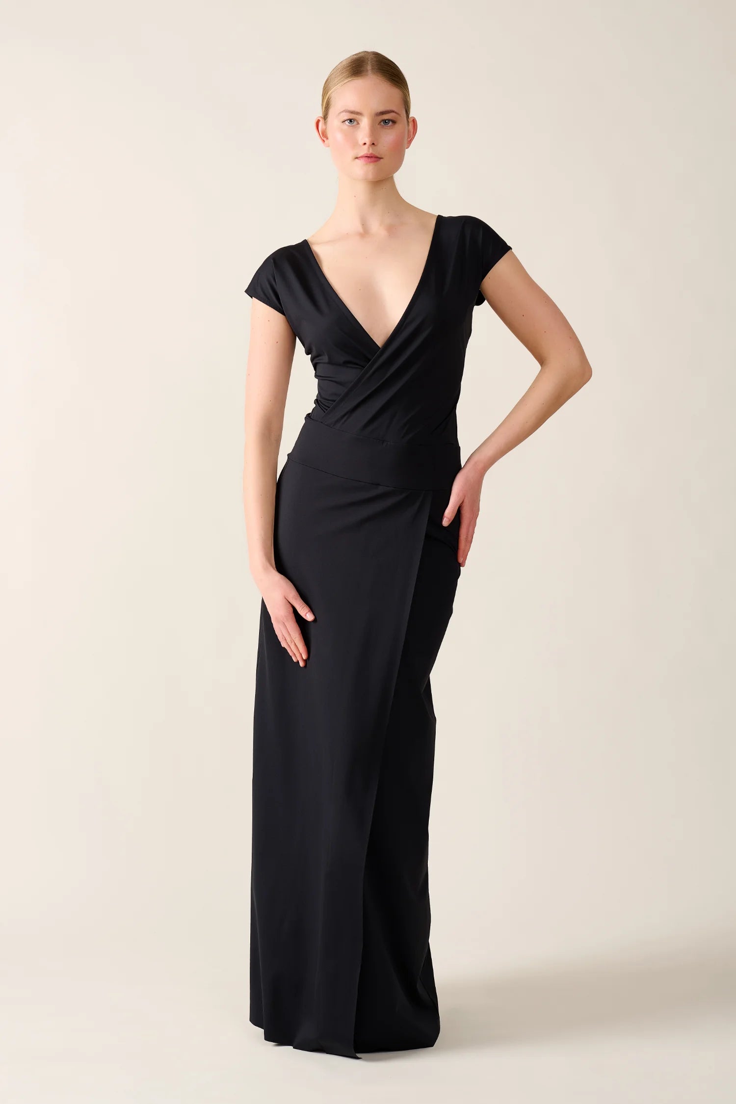 Elegantes, schwarzes MYMARINI-Kleid mit V-Ausschnitt und kurzen Ärmeln, getragen von einer Person vor neutralem Hintergrund.#color_black