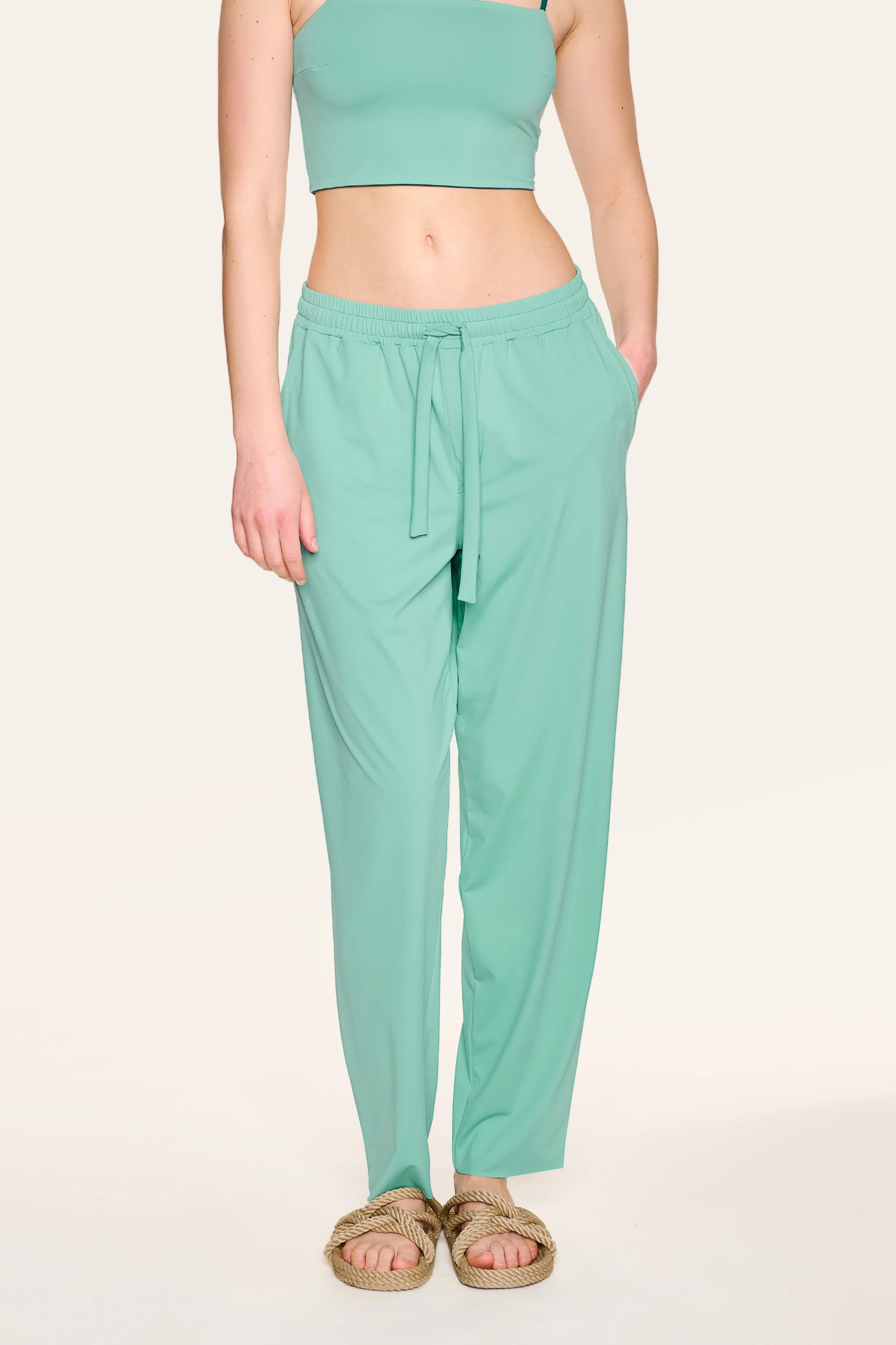 Person trägt mintgrüne MYMARINI-Hose mit elastischem Bund und Kordelzug, kombiniert mit einem Bandeau-Top.#color_eucalyptus