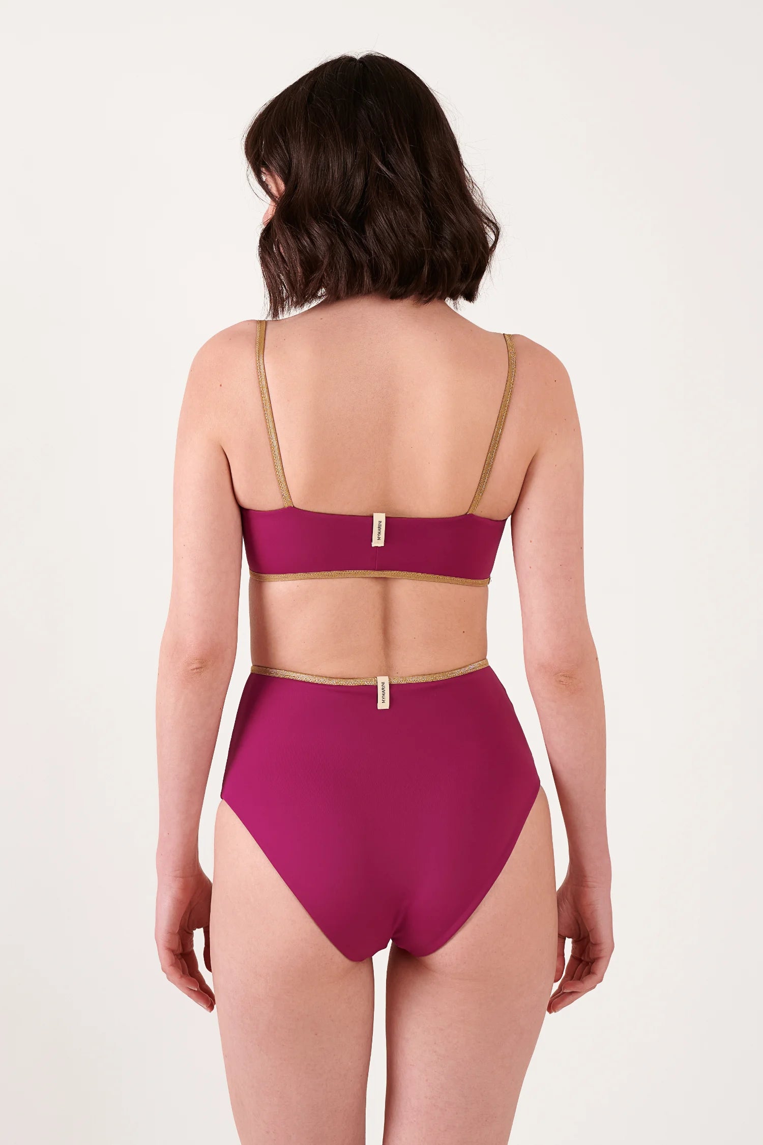 MYMARINI Bikini-Set in Magenta mit goldener Bordüre; Rückansicht mit dünnen Trägern, Bikinihose mit hohem Beinausschnitt.#color_maroon-hortensia