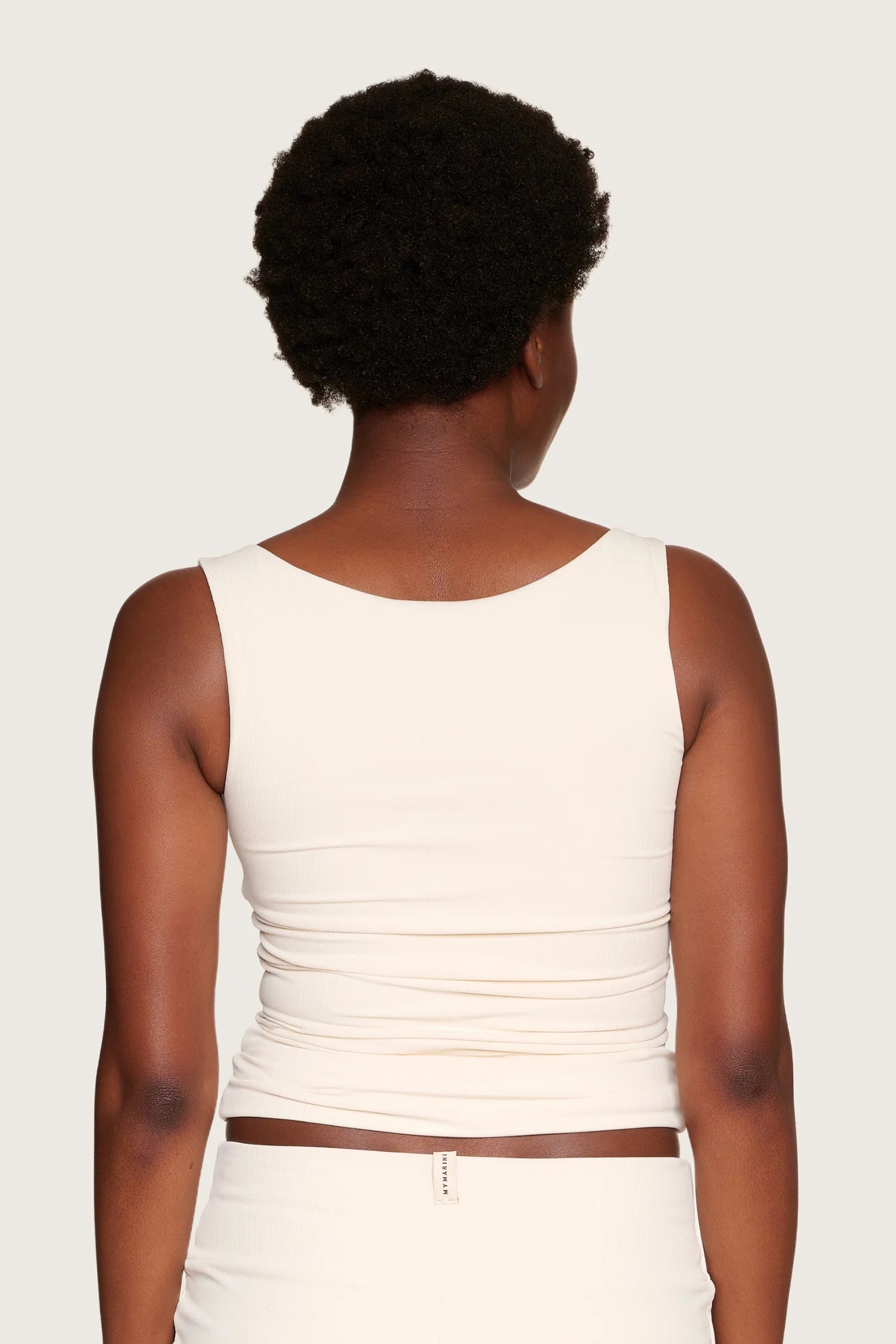 Person von hinten in cremefarbenem MYMARINI-Top mit breiten Trägern und passender Hose.#color_off-white